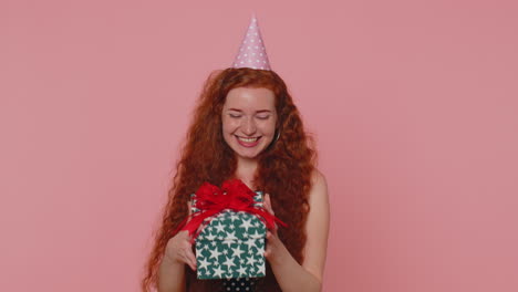 Cheerful-young-redhead-woman-opening-gift-box,-unwrapping-birthday-surprise-and-expressing-happiness