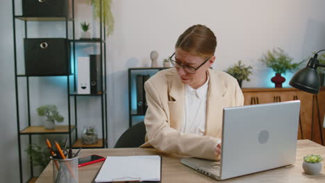 Geschäftsfrau,-Die-Im-Büro-Am-Laptop-Arbeitet-Und-Angst-Hat,-Die-Uhrzeit-Auf-Der-Uhr-Zu-überprüfen,-Ob-Es-Zu-Spät-Ist-Und-Die-Deadline