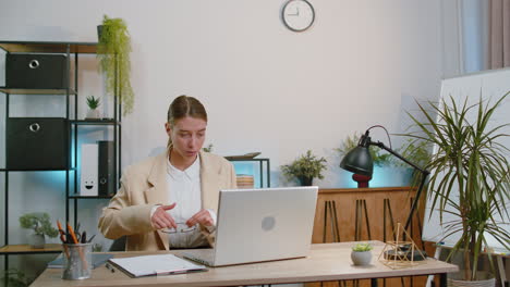 Una-Mujer-De-Negocios-Independiente-Ingresa-Al-Lugar-De-Trabajo-De-La-Oficina,-Trabaja-En-Una-Computadora-Portátil-Y-Envía-Mensajes-En-Línea