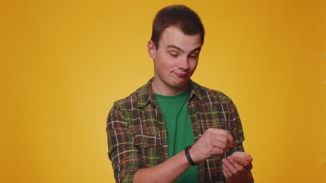 Cheerful-young-man-in-shirt-looking-at-camera-doing-phone-gesture-like-says-hey-you-call-me-back