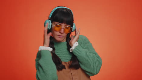 Young-happy-woman-in-headphones-listening-music-and-dancing-disco-having-fun-relaxing-on-party