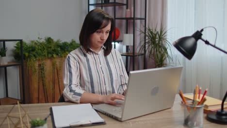 Mujer-Joven-Empresaria-Sentada-En-La-Oficina-De-Casa-Cerrando-La-Computadora-Portátil-Después-De-Terminar-El-Trabajo,-Aprendizaje-Electrónico