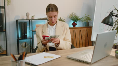 Mujer-De-Negocios-Rica,-Chica-Que-Trabaja-En-Un-Teléfono-Inteligente-Contando-Dinero-En-Efectivo,-Calcula-Ganancias,-Ingresos-Y-Ganancias.