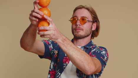 Handsome-tourist-young-man-holding-showing-oranges-fruits,-vegetarian-lifestyle,-vitamins-for-health