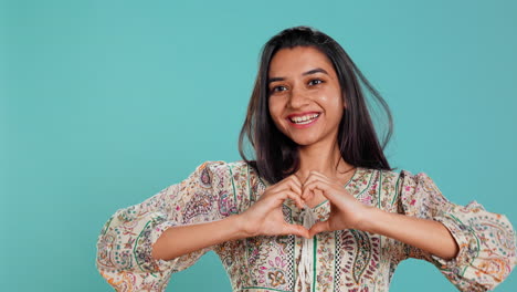 Retrato-De-Una-Mujer-Amorosa-Sonriente-Haciendo-Gesto-Con-Forma-De-Símbolo-De-Corazón