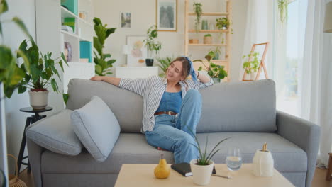 Happy-Woman-Embracing-Life-on-Sofa