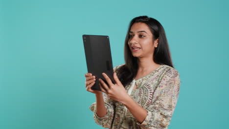 Woman-having-friendly-discussion-during-teleconference-meeting-using-tablet