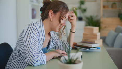 Mujer-Reflexiva-Aprendiendo-En-El-Escritorio-En-Casa