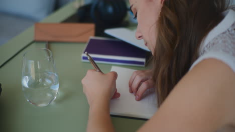 Mujer-Escribiendo-Cuaderno-Aprendizaje-En-Línea