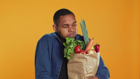 Young-adult-accidentally-dropping-an-apple-from-his-paper-bag