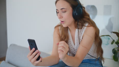 Smiling-Woman-on-Video-Call-with-Friend-While-Sitting-on-Sofa