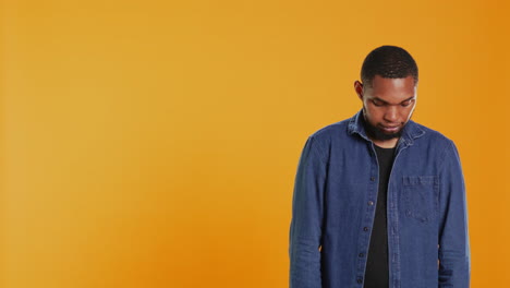 Portrait-of-confident-person-smiling-on-camera-against-orange-background