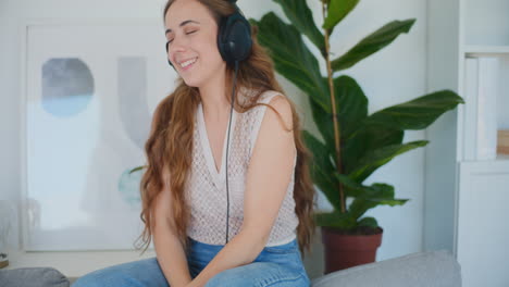 Woman-Dancing-on-Sofa-Listening-to-Music