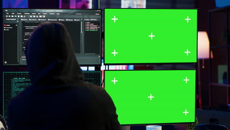 Close-up-of-hacker-running-code-in-apartment-on-PC-monitors