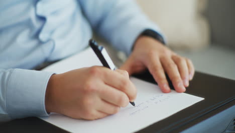 Close-Shot-of-Businessman-Writing-Financial-Report