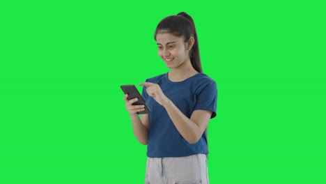 Happy-Indian-teenage-girl-scrolling-phone-Green-screen