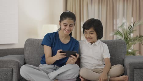 Happy-Indian-sibling-watching-video-on-mobile-phone