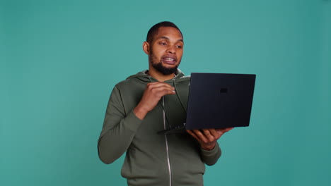 Man-in-teleconference-meeting-with-friends-using-laptop