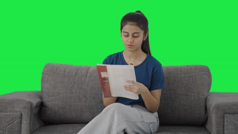 Serious-Indian-teenage-girl-reading-books-Green-screen