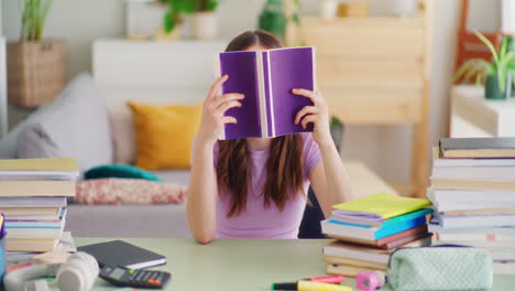 Una-Joven-Colegiala-Comienza-A-Leer-Un-Libro-En-Su-Escritorio.