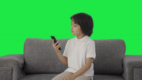 Un-Niño-Indio-Serio-Desplazándose-Por-La-Pantalla-Verde-Del-Teléfono