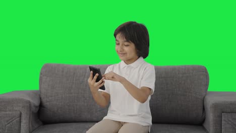 Happy-Indian-boy-scrolling-through-phone-Green-screen