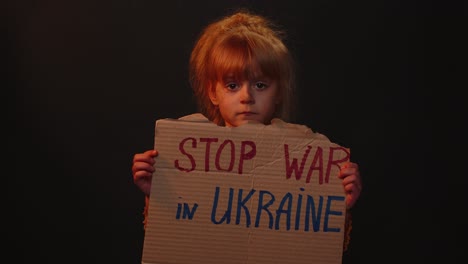 Homeless-girl-kid-showing-cardboard-massage-Hands-Off-Ukraine,-crisis-war,-no-peace,-stop-aggression