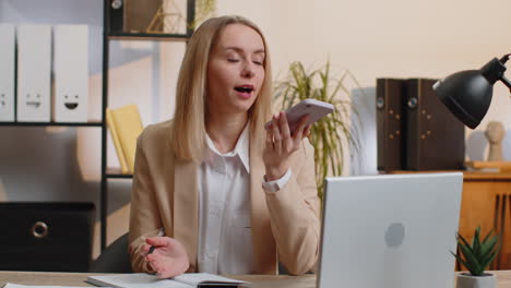 Young-business-woman-working,-having-mobile-phone-talk-at-office-workplace-using-messenger-chat-apps