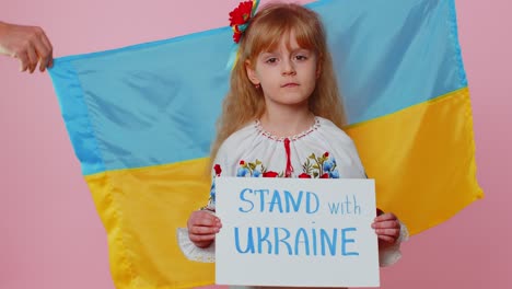 Sad-toddler-Ukrainian-girl-kid-in-embroidery-protesting-war-conflict-raises-banner-with-inscription