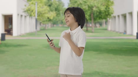 Niño-Indio-Perezoso-Desplazando-El-Teléfono-En-El-Parque