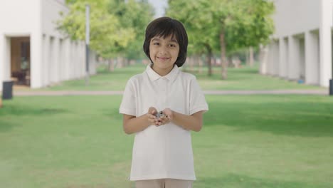 Happy-Indian-boy-holding-lot-of-coins-in-hand-in-park