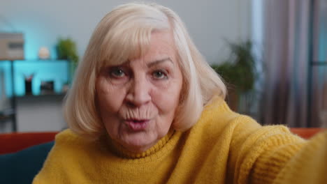 Pov-Anciana-Abuela-Mujer-Haciendo-Videollamada-Selfie-En-Línea-Hablando-Saludando-Con-La-Mano-Mirando-A-La-Cámara