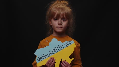 Sad-homeless-child-girl-protesting-war-conflict-raises-banner-with-inscription-Hands-Off-Ukraine