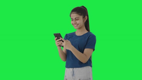 Happy-Indian-teenage-girl-texting-someone-Green-screen