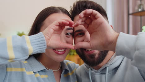 Family-married-couple-makes-symbol-of-love,-showing-heart-sign-to-camera,-express-romantic-feelings