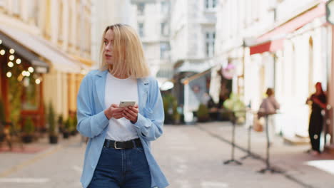 Mujer-Joven-Turista-Viajera-Usando-Un-Teléfono-Inteligente-Escribiendo-Mensajes-De-Texto-Buscando-Buscar-Una-Manera-En-El-Mapa