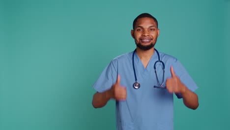 Cheerful-male-nurse-showing-thumbs-up-signs