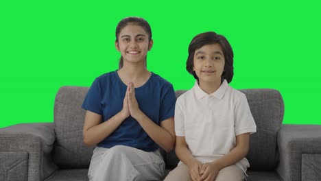 Happy-Indian-siblings-doing-Namaste-to-the-camera-Green-screen