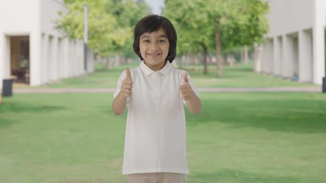 Happy-Indian-boy-showing-thumbs-up-in-park