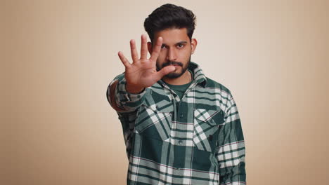 Indian-man-say-No-hold-palm-folded-crossed-hands-in-stop-gesture-warning-of-finish-prohibited-access