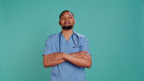 Portrait-of-joyful-male-nurse-standing-with-arms-folded