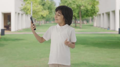 Happy-Indian-boy-talking-on-video-call-in-park