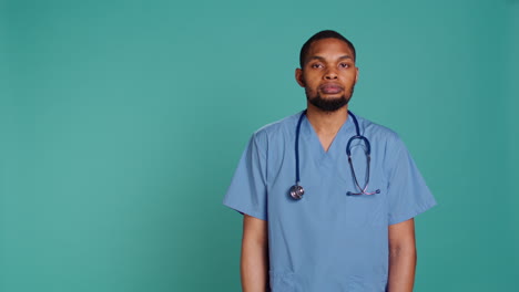 Sad-male-nurse-showing-thumbs-down-signs-while-at-work