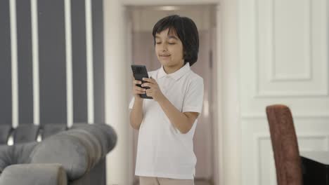 Happy-Indian-boy-texting-someone-on-phone