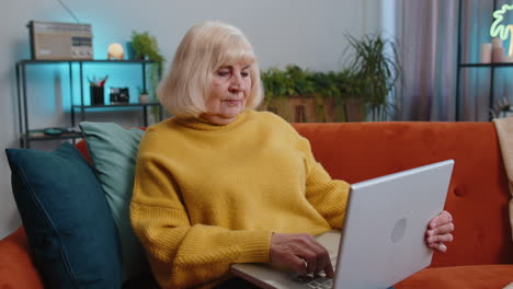 Abuela-Mujer-Independiente-En-El-Sofá-Cerrando-La-Computadora-Portátil-Después-De-Terminar-El-Trabajo-En-La-Sala-De-Estar-En-Casa