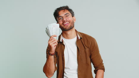 Rich-happy-Indian-man-winner-waving-money-dollar-cash-like-a-fan,-big-income-wealth-success-business