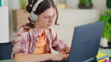 Concentrated-Teenager-While-Doing-Homework-on-Laptop