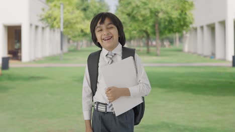 Happy-Indian-school-boy-standing-with-books