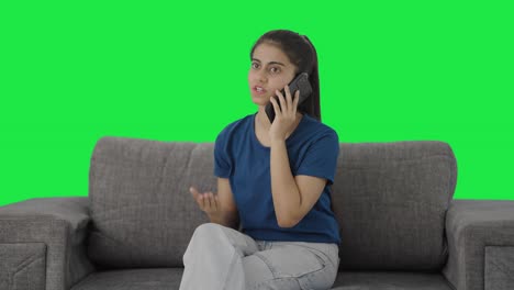 Serious-Indian-teenage-girl-talking-on-call-Green-screen