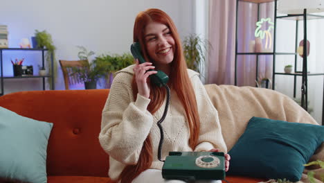 Woman-making-retro-telephone-from-90s-conversation-with-friends-sitting-call-on-sofa-at-home-in-room